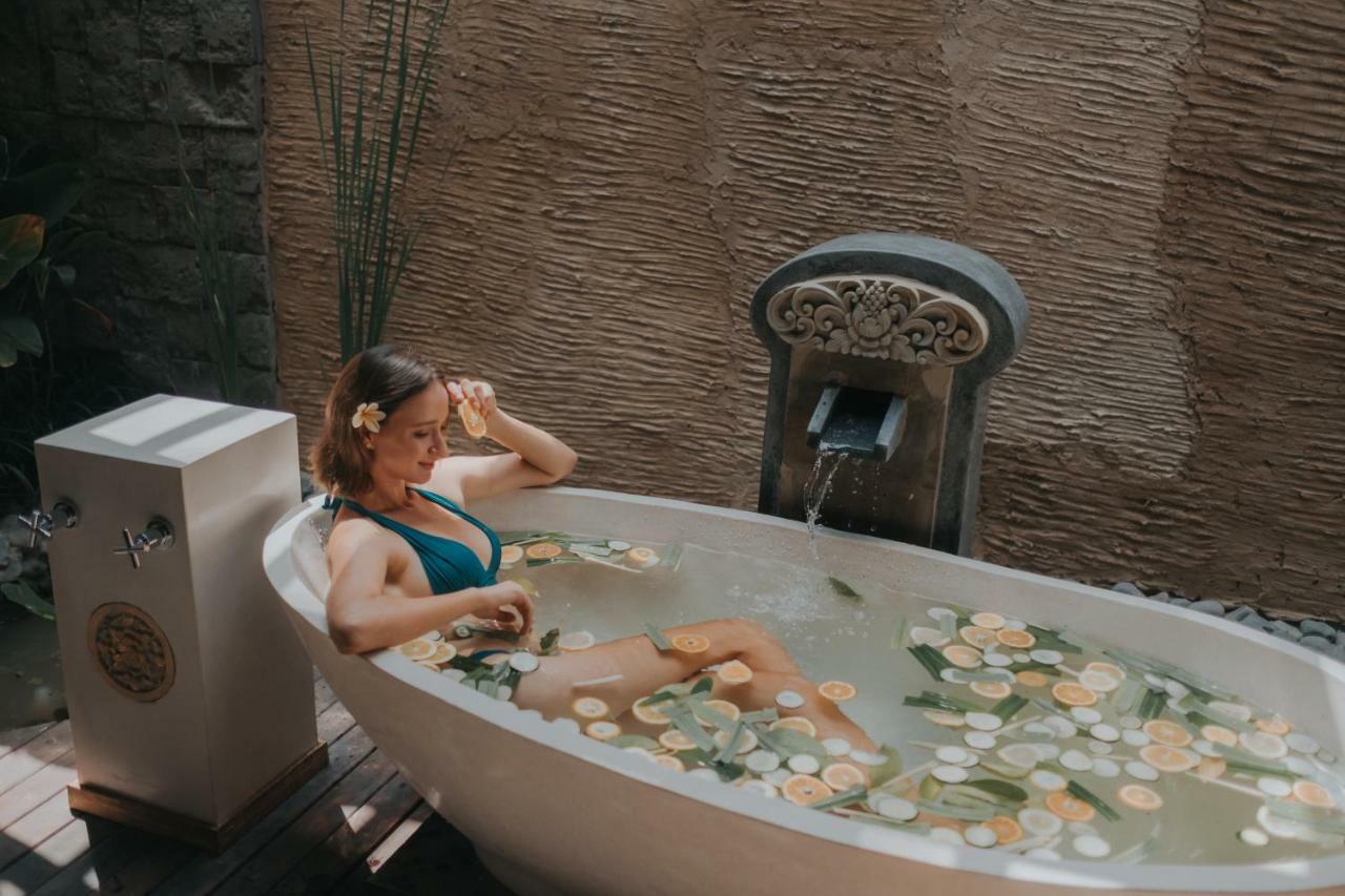 Kuwarasan A Pramana Experience Hotel Ubud Exterior foto A woman bathing in a bathtub